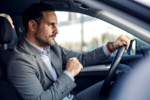 Experienced chauffeur driving an airport taxi service vehicle